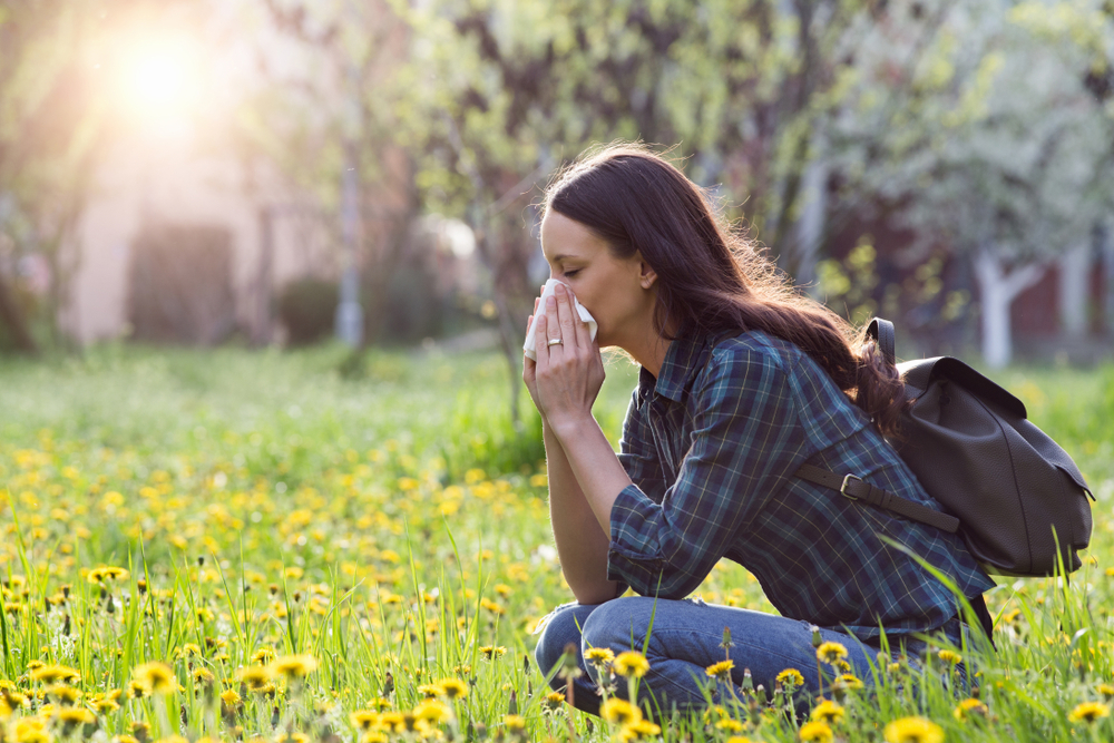 Young,Pretty,Woman,Blowing,Nose,In,Grassland,With,Spring,Flowers.